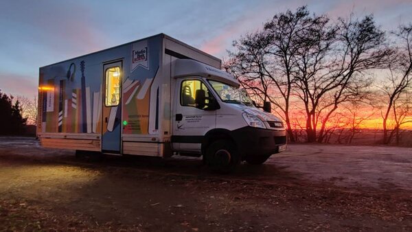 Bild der Fahrbibliothek am Haltepunkt Kulkwitz bei Sonnenuntergang